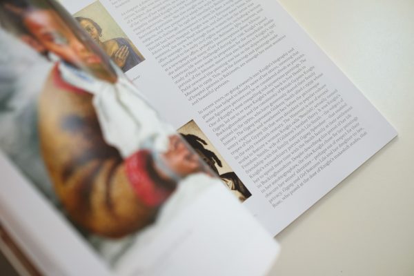 photograph inside book with text and portrait painting