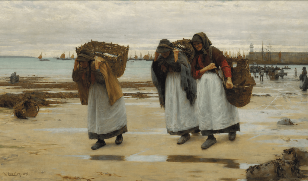 Three women in headscarves and white aprons walk across a sandy beach, carrying large woven baskets on their backs near a harbour with many boats.