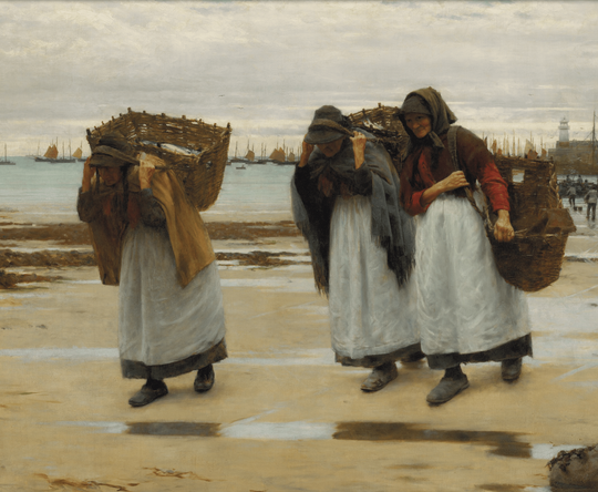 Three women in headscarves and white aprons walk across a sandy beach, carrying large woven baskets on their backs near a harbour with many boats.