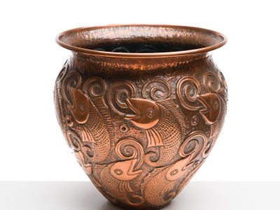 Ornate bronze vase with intricate fish and swirl patterns on its surface, set against a plain white background. The design conveys an elegant, artistic tone.
